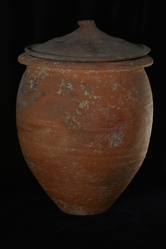 Convex lid with thickened edge and prominent wheel marks; in center of top a deformed short cylindrical handle which shows on surface striations of surface on which lid left to dry.