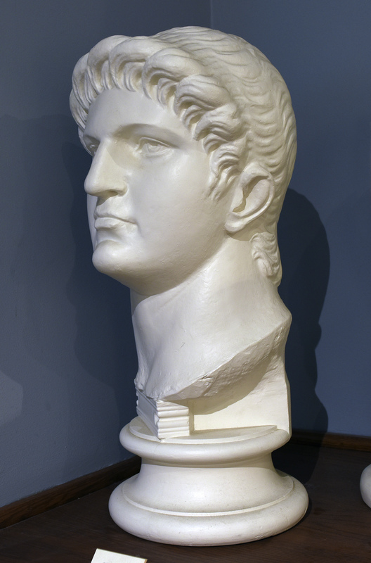 Cast based on an original in the British Museum. Nero Claudius Caesar, born in Antium in 37 to Gnaeus Domitius Ahenobarbus and Agrippina the Younger, was one of Rome’s most intriguing emperors. His mother was the fourth wife of the emperor Claudius and she persuaded him to adopt her son Nero. Agrippina’s malicious intentions were to kill Claudius so that her son would attain the position of emperor, so upon Claudius’ untimely death, seventeen-year-old Nero ascended to the throne in the year 54.

Nero’s personal accomplishments were numerous: he played the lyre, sang, recited his own poetry, competed in the Olympic games, and enjoyed painting and sculpture. Nero is most remembered by the quote, “Nero fiddled while Rome burned,” which may hold some truth. Apparently after a devastating fire ravaged the city of Rome in 64, Nero took the opportunity to displace citizens and build a grand palace for himself called the Domus Aurea in the center of the city. By this time Nero was out of control, and in 65, many high ranking Romans planned the Pisonian conspiracy: a plot to assassinate Nero and name Gaius Calpurnius Piso as the new emperor. Nero unfortunately discovered their plans and put many people to death including his tutor Seneca. Many people died at the hands of Nero throughout his reign including his wife Poppaea, his mother Agrippina, and countless others. The extremely unpopular emperor eventually died at the age of thirty-two after committing suicide in the year 68, “reputedly lamenting, ‘What an artist dies with me!” (Hornblower and Spawforth, 1038).

Nero’s portraiture is rather hard to study chronologically since so many of his portraits were destroyed or defaced after his death. Many coins have survived that show Nero as the emperor, but less then 25 sculptures remain and most of them depict Nero in his youth. His physical characteristics include, “high cheekbones, fleshy jaw and neck, and a full head of tousled hair that is brushed from the crown of his head, low on the forehead,” (Kleiner 136). In later sculptures, like this replica at the Wilcox collection, which depicts Nero at about thirty years of age, his features are primarily the same as those in his youth with one exception: In these busts, his hair is styled in such a way that his wavy hair is culed tightly, especially around his face, and these curls are pushed up forming a wave or crown over his forehead. Nero’s portraits are interesting because although Nero was young when he died, his portraiture reflects the aging process and his differing psychological states as he matures from a boy with youthful exuberance to a paranoid megalomaniac.