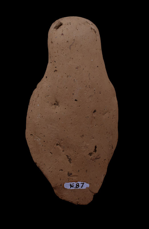 Mouldmade standing figure w himation draped over head and falling down over outside of r arm, coming forward over l breast, w fold coming across fr r side and tucked under l arm folds of chiton and himation articulated by incision.  Hairline, eyes, nose, and mouth articulated by incision.