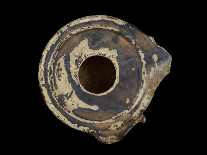 Handleless reservoir w almost straight sides rising from carination just above ring base; almost flat discus w large fill hole surrounded by two raised ridges of metal prototype; dolphin lug at one side.  Sides, discus, nozzle & dolphin coated w now dull, dark metallic paint which also on parts of int & base.