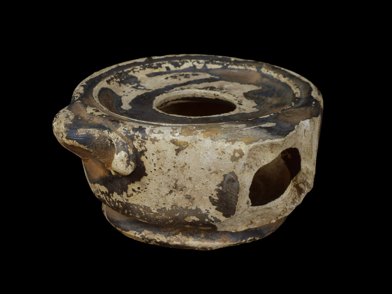 Handleless reservoir w almost straight sides rising from carination just above ring base; almost flat discus w large fill hole surrounded by two raised ridges of metal prototype; dolphin lug at one side.  Sides, discus, nozzle & dolphin coated w now dull, dark metallic paint which also on parts of int & base.