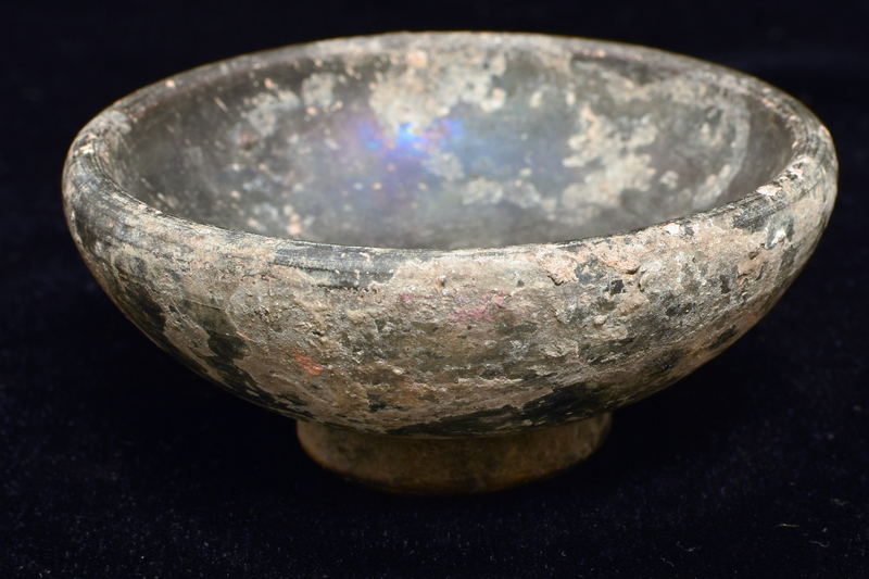 Convex-sided bowl w high max D just below fairly thick rim, ring base deeply concave w central nipple on underside.  Coated all over w dark paint.