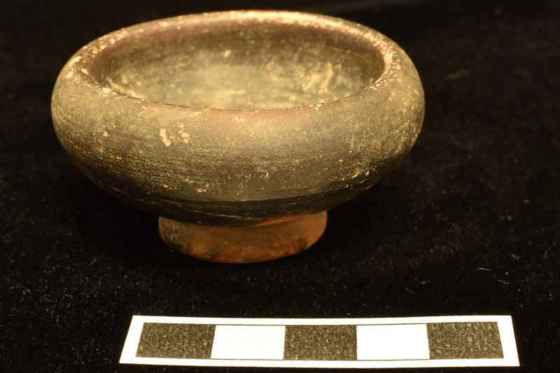 Convex-sided bowl w high maximum D on ring base, shallowly concave w central nipple.  Thick plain rim.  Coated all over except for part of lower body and much of underside of base w dark paint.