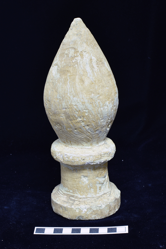 Pointed phallic symbol  on base resembling circular altar with fairly shallowly concave sides with plain thick, projecting  discoid moldings above and below, the lower greater in diameter than the upper.  Strong rasp marks all over, vertical on symbol, horizontal on base.