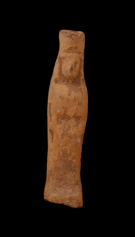 Mouldmade standing female of Dadaelic type with tall polos. Bilaterally symmetrical with arms close to sides, probably wearing simple tunic belted at waist. Triangular contour of face, nose articulated with slight depressions for eyes on either side; some indication of mass of hair straight across forehead. Stands on squarish base, articulated primarily at front.