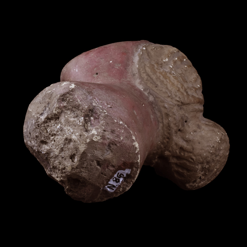 Head and neck of female with wig-like hair parted in middle and pulled back into a bun, hair strands marked by broad sawtooth impressions.  Flat oval face projecting forward with plastic eyes with pupils incised, prominent nose with nostrils indicated, and with horizontal mouth slit on raised surface indicating lips, upper lip with slight horizontal depression at center.  Thick neck spreading toward break, possibly not attached to a body but some kind of base.  Flesh painted reddish, hair showing traces of white paint which is better preserved on forehead in front of hair mass.