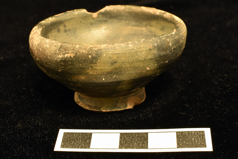Bowl w almost straight sides spreading from high ring base, deeply conical on underside, to ca 3/4 h from which they curve in to thick, plain rim.  Coated int & ext w dark paint,  except for underside of base.