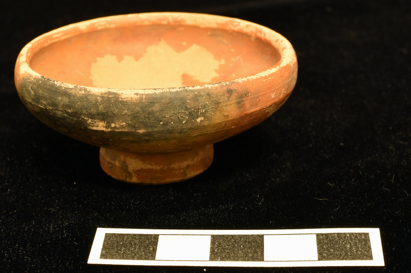 Convex-sided bowl w distinct inward curve in upper section to rim, ring base with concave, nippled underside.  Coated all over w reddish paint.