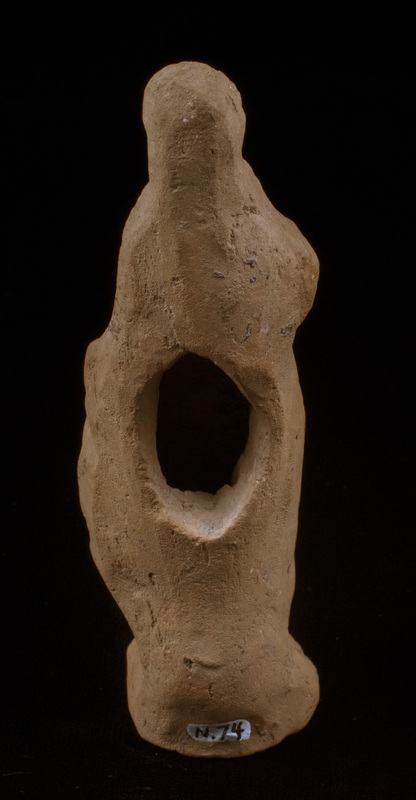 Mouldmade standing figure of Sophoclean type with right arm and hand completely covered by himation and left arm, slightly bent, close to side with large clump of drapery falling forward from left hand; left foot projecting slightly before right, small base.  Eyes, mouth and nose articulated and irregular incisions articulating hair mass which is particularly defined around face.  Very large vent hole in plain back.