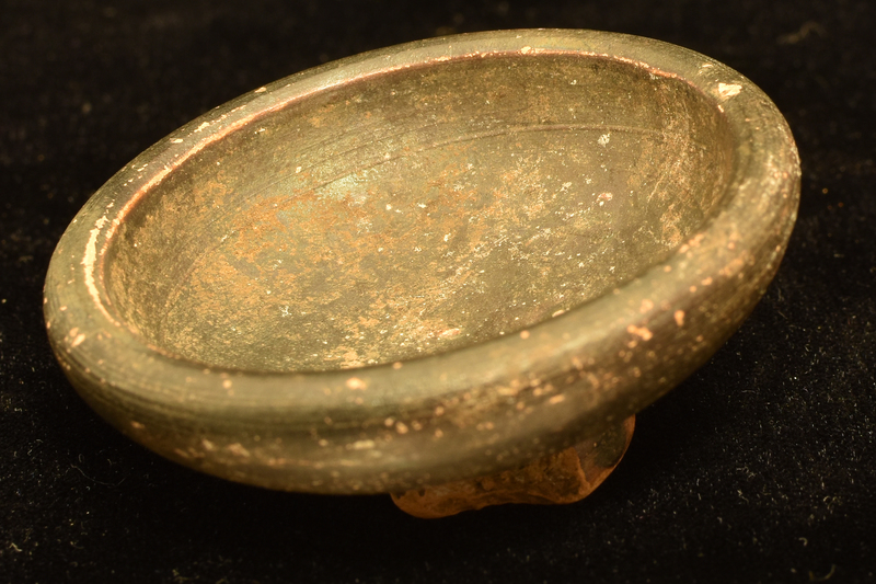 Low bowl w wide-spreading sides, very thick rim; ring base, deeply concave w prominent nipple occupying most of center.  Coated inside and out w dark paint which also covers part of underside of base.