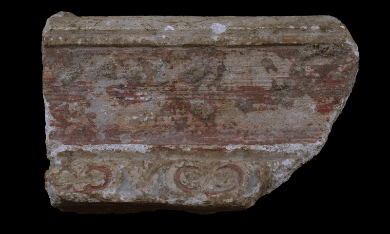 Moulded cornice w sloping face of overhanging upper portion   decorated w relief w ivy leaves painted green & red on white background; central section , plain & vertical, painted red & finished w small torus at lower edge, below which green stripe & traces of insloping ?wall surface.  No original surface preserved on back.